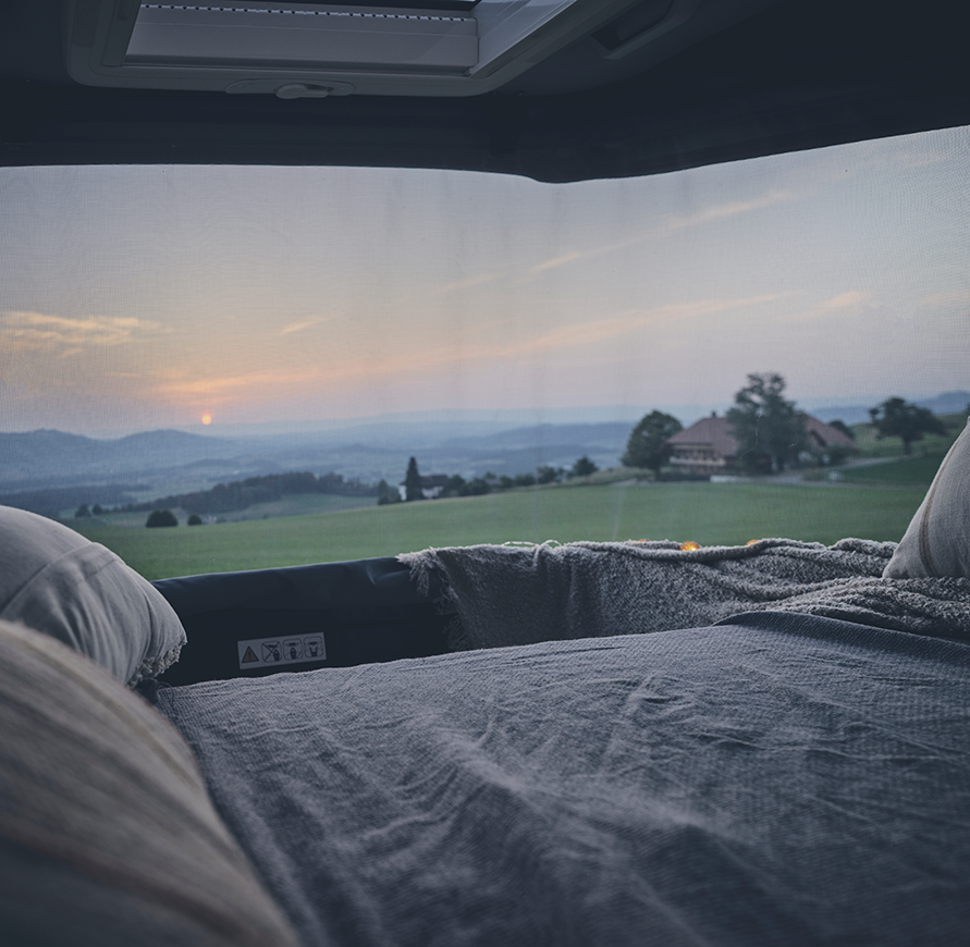 Sunlight CLIFF 600 Adventure mit Schlafdach, Blick auf die Felder und ins Tal mit idyllischem Bauernhaus, Sonnenaufgange, kuschligen Decken und Kissen